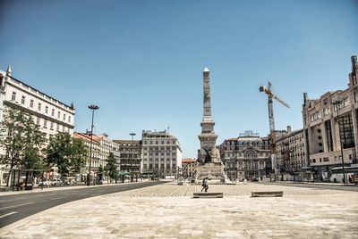 Buildings in city against clear blue sky