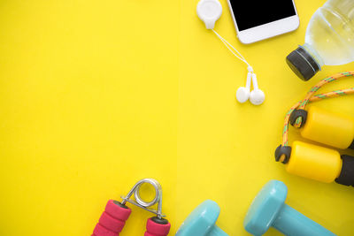 High angle view of mobile phone on yellow table