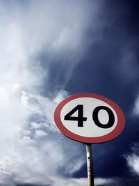 Low angle view of road sign against cloudy sky