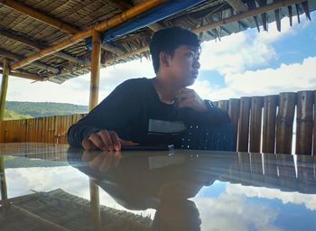 Reflection of man in water against sky