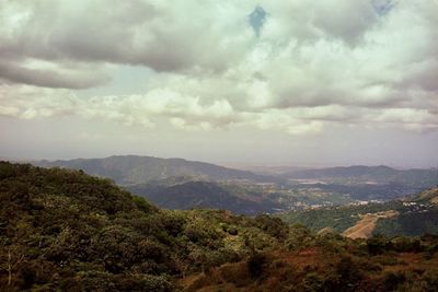 Scenic view of mountains against cloudy sky