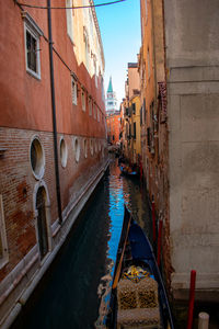 Canal amidst buildings in city against sky