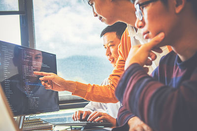 Business colleagues discussing over desktop pc in office