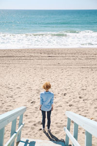 Rear view of woman standing on beach