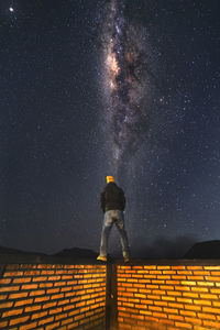 Rear view of man standing against star field at night