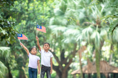 Boy playing with flag against blurred background