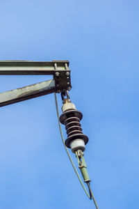 Low angle view of telephone pole against clear blue sky