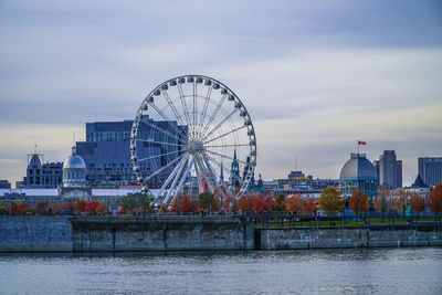 Ferris wheel by sea against sky