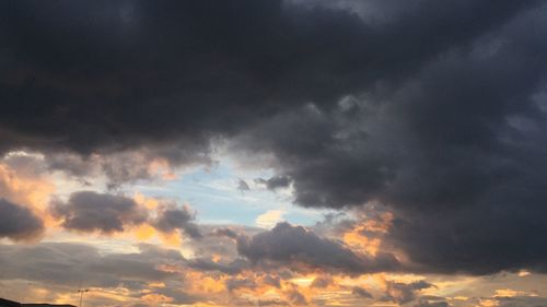 Low angle view of storm clouds in sky during sunset