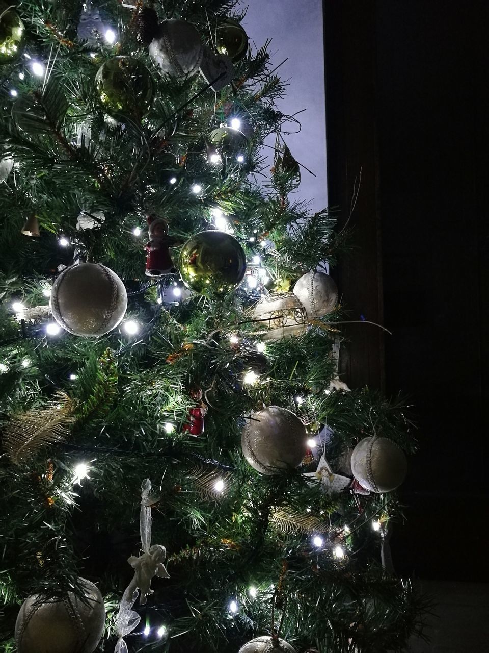 LOW ANGLE VIEW OF ILLUMINATED CHRISTMAS TREE AGAINST SKY