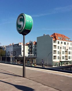 Street amidst buildings against clear blue sky