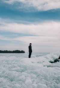 Man standing on snow field against sky