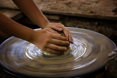 Cropped hands of woman molding mud