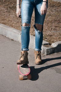 Low section of woman standing on road