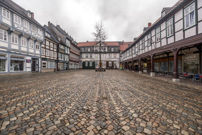 Street amidst houses in town against sky