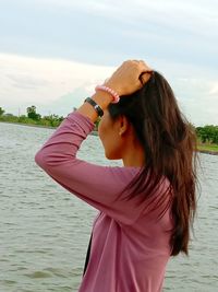 Portrait of woman standing in water against sky