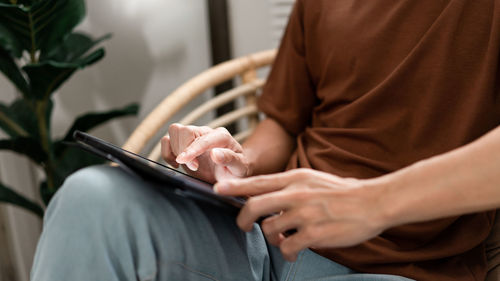 Midsection of man using mobile phone