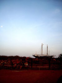 Ship moored on shore against sky