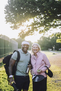 Smiling senior woman standing with mature male friend