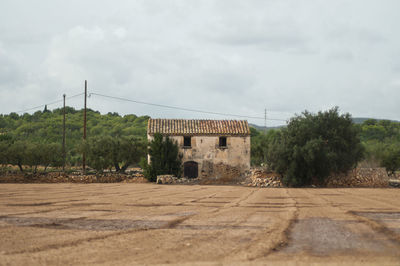 Abandoned building on field against sky