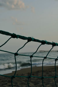 Close-up of barbed wire fence against sky