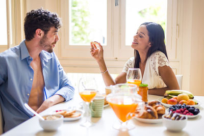 Couple eating food while sitting at home