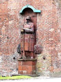 Statue against brick wall