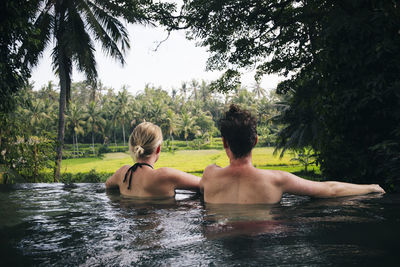 Rear view of two men in water