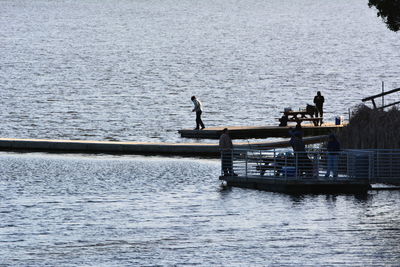 People in boat sailing on sea