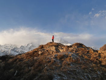 Hiker standing on mountain against sky