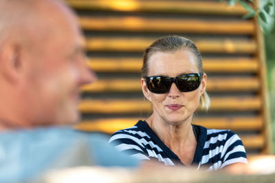 Middle-aged couple relaxing together in the garden and talking, closeup portrait of a woman