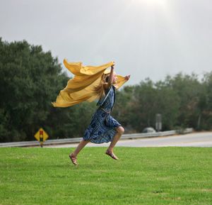 Low angle view of woman jumping on field