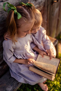 Top view of two children holding a book