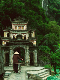 Rear view of man standing by historic building