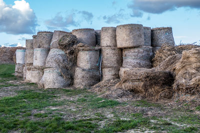 Hay bales on field against sky