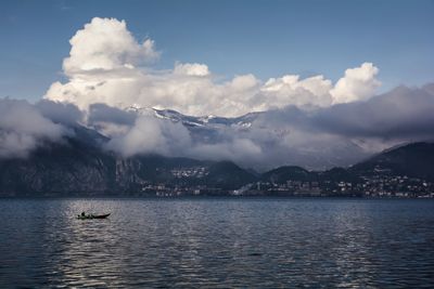 Clouds covering mountains by lake