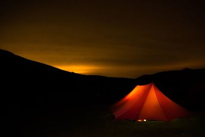 Scenic view of illuminated mountains against sky at night