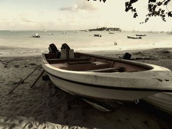 Boats moored on beach against sky