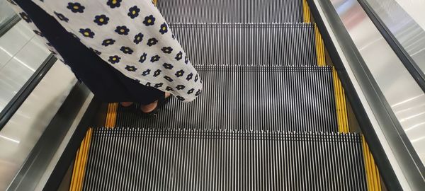 High angle view of woman standing on escalator