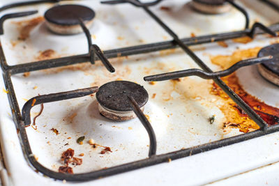 Dirty stove with food leftovers. unclean gas kitchen cooktop, greasy spots, old fat stains, fry spot