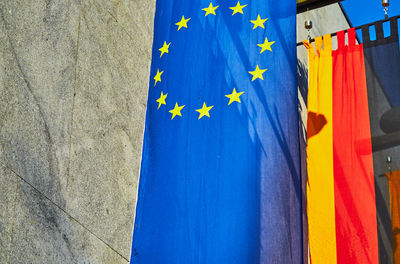 Close-up of flags hanging against blue sky