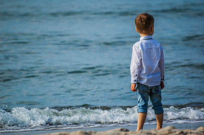 Rear view of boy standing on beach