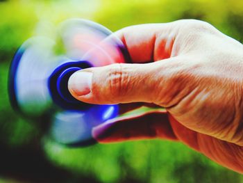 Close-up of hand holding multi colored blurred background