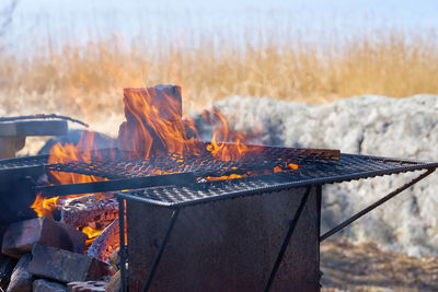 Fire in a rusty vintage grill outdoor on the beach of the sea.