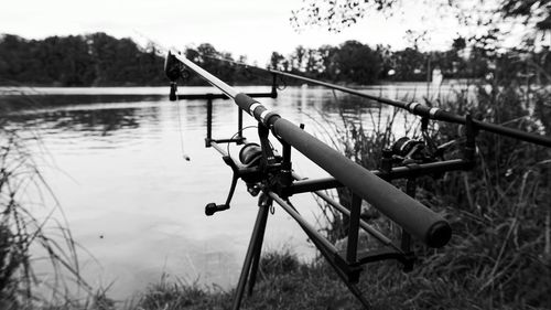 Bicycle by lake against sky