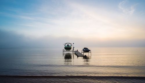 Floating platform amidst boat in lake superior against sky