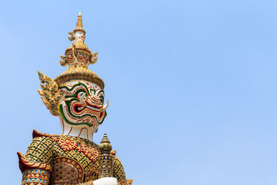 Low angle view of statue against temple against clear sky