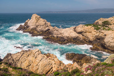 Scenic view of rocks on beach against sky