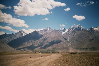 Idyllic shot of dirt road against himalayas at ladakh