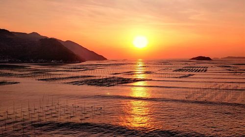 Scenic view of sea against orange sky